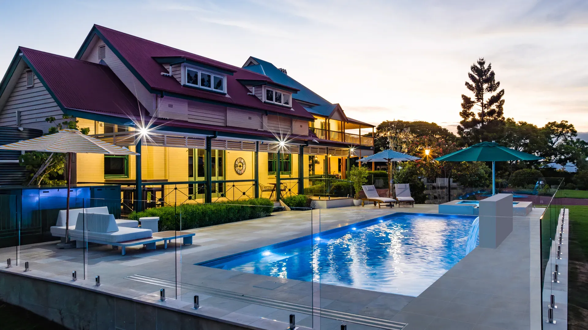 Luxury pool installation at twilight with Queenslander home