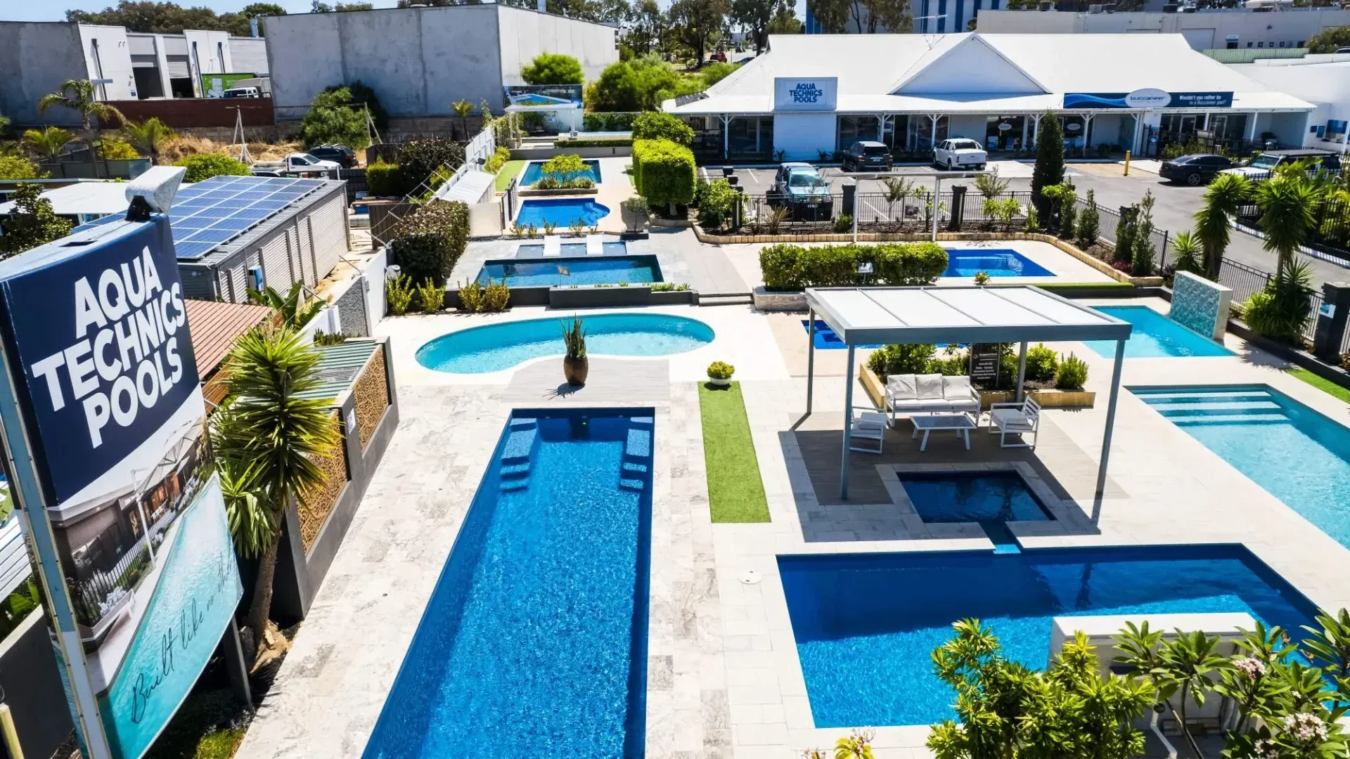 Aqua Technics fibreglass pools on show across the MFP Easy display centre with paved surrounds and a shaded lounge